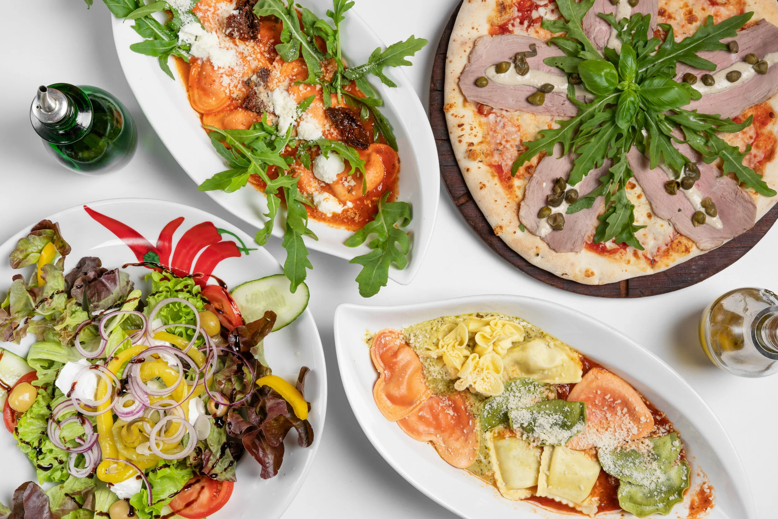 Auswahl italienischer Gerichte: Pizza, frischer Salat und gefüllte Pasta