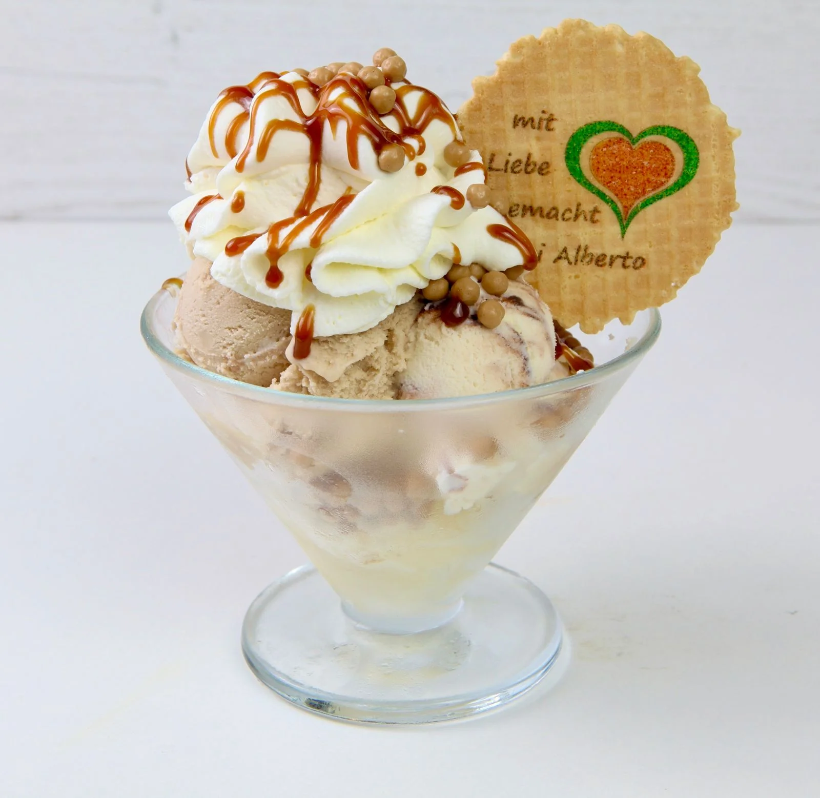 Karamell-Eisbecher mit Sahne, Karamellsauce und Karamellperlen