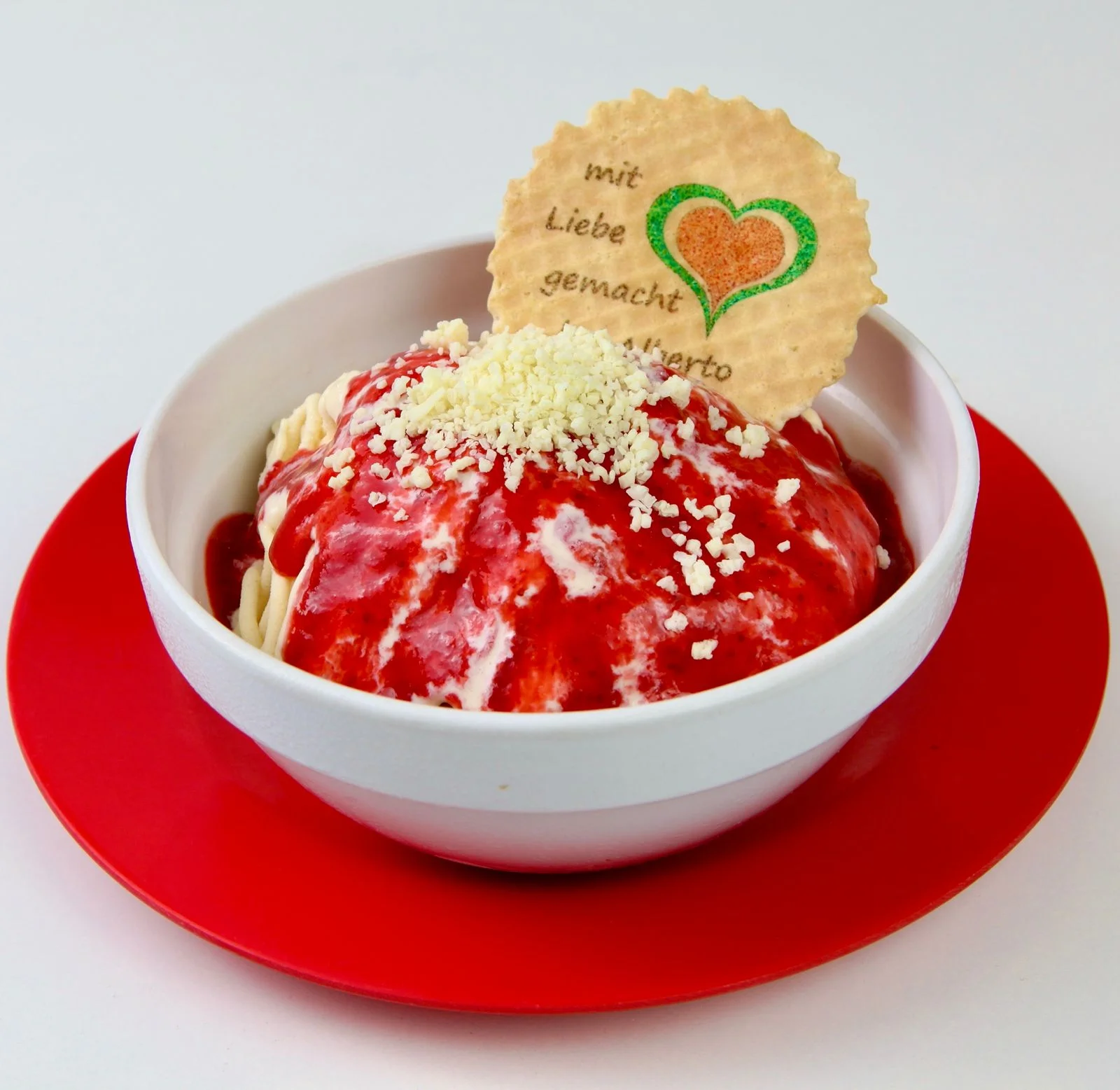 Erdbeer-Spaghetti-Eis mit weißen Schokoraspeln und Herz-Waffel