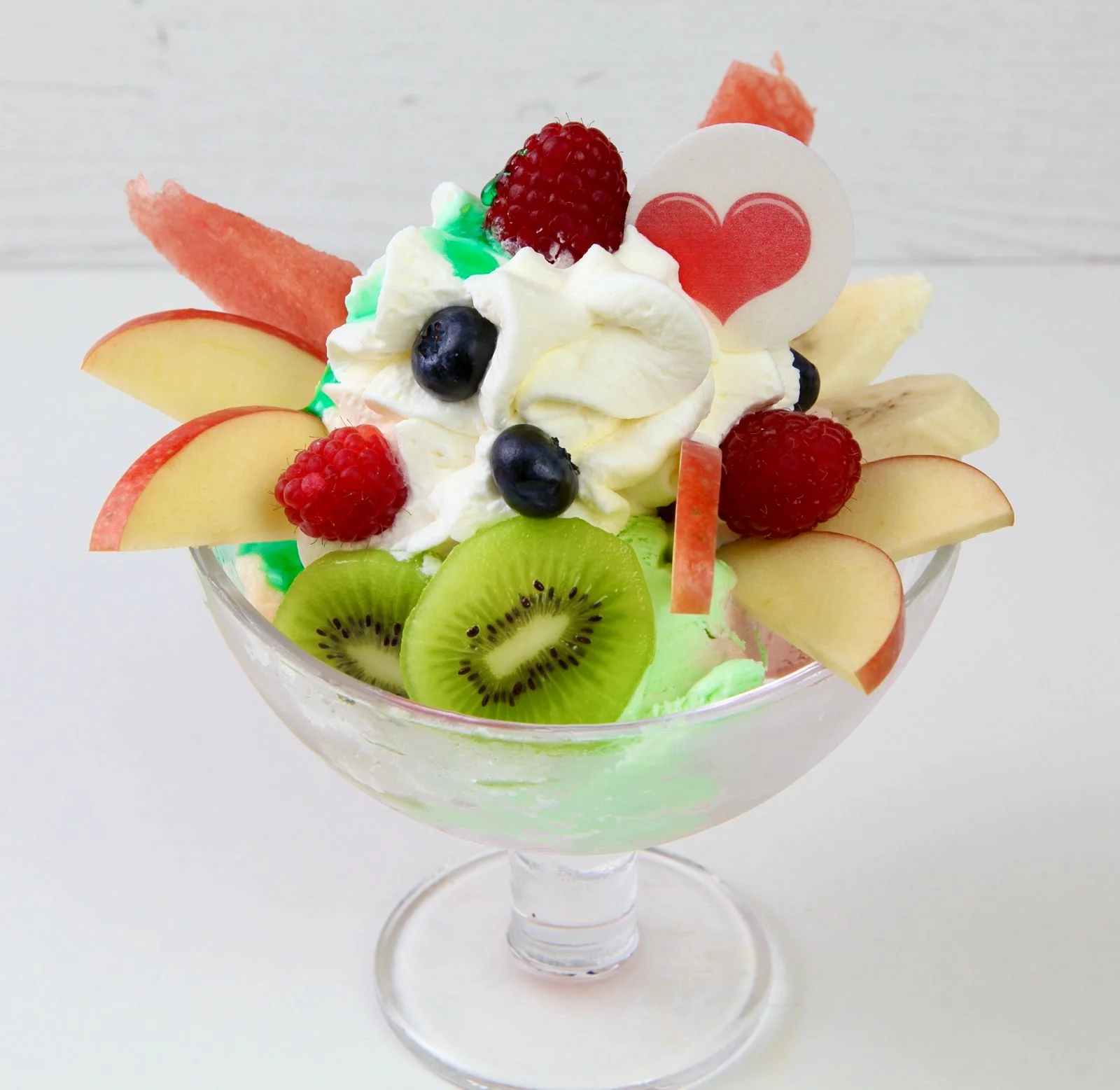 Frucht-Eisbecher mit Kiwi, Himbeeren, Apfel, Heidelbeeren und Banane